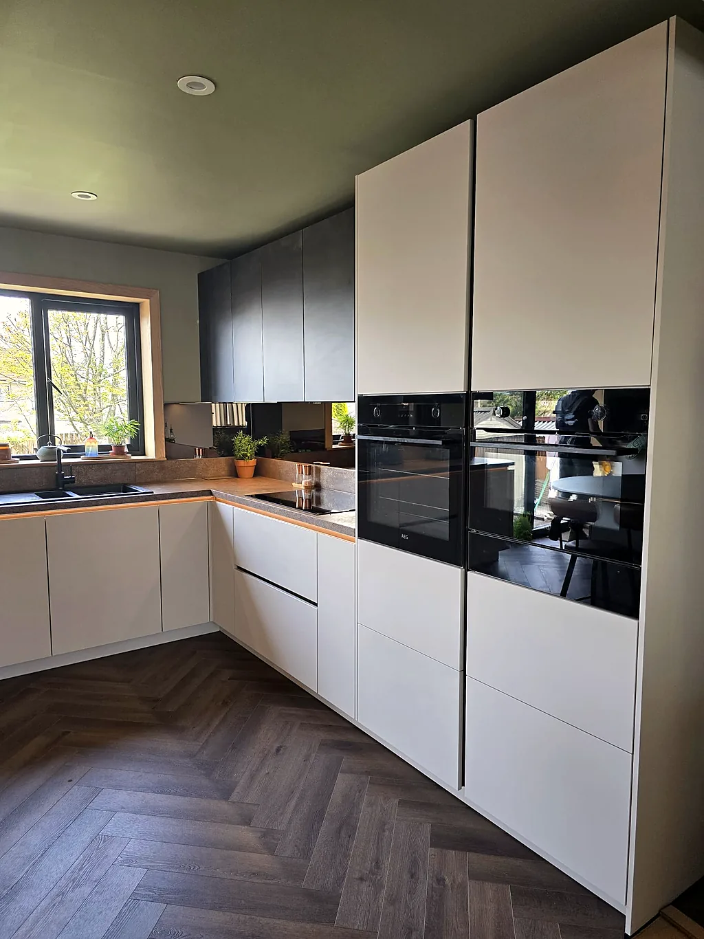 Modern handleless kitchen with mirror splashback after renovation