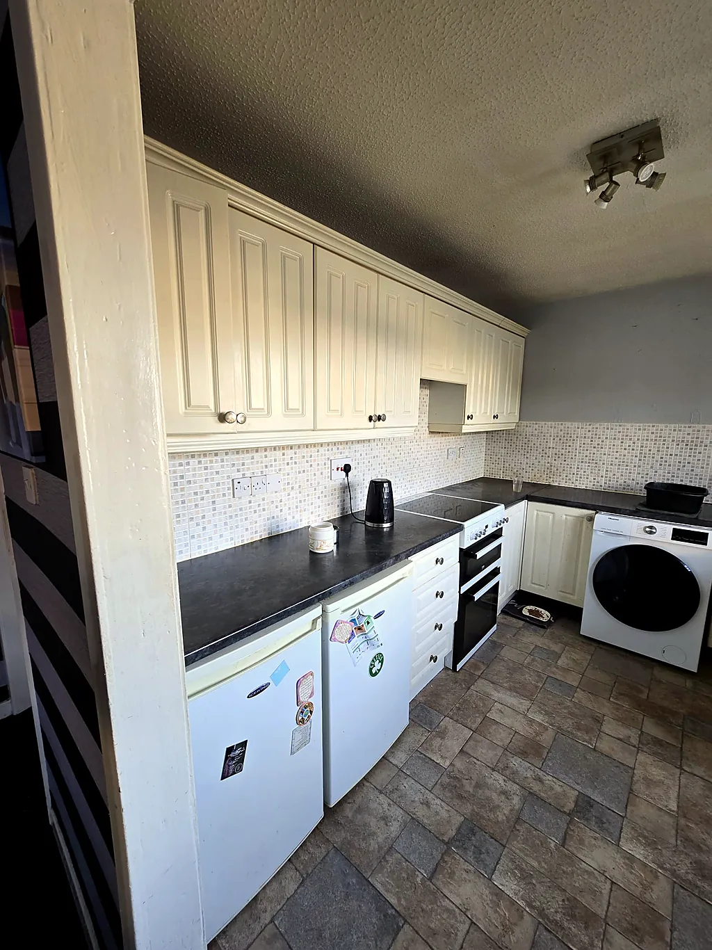 Dated cream kitchen with raised-panel doors before the refit
